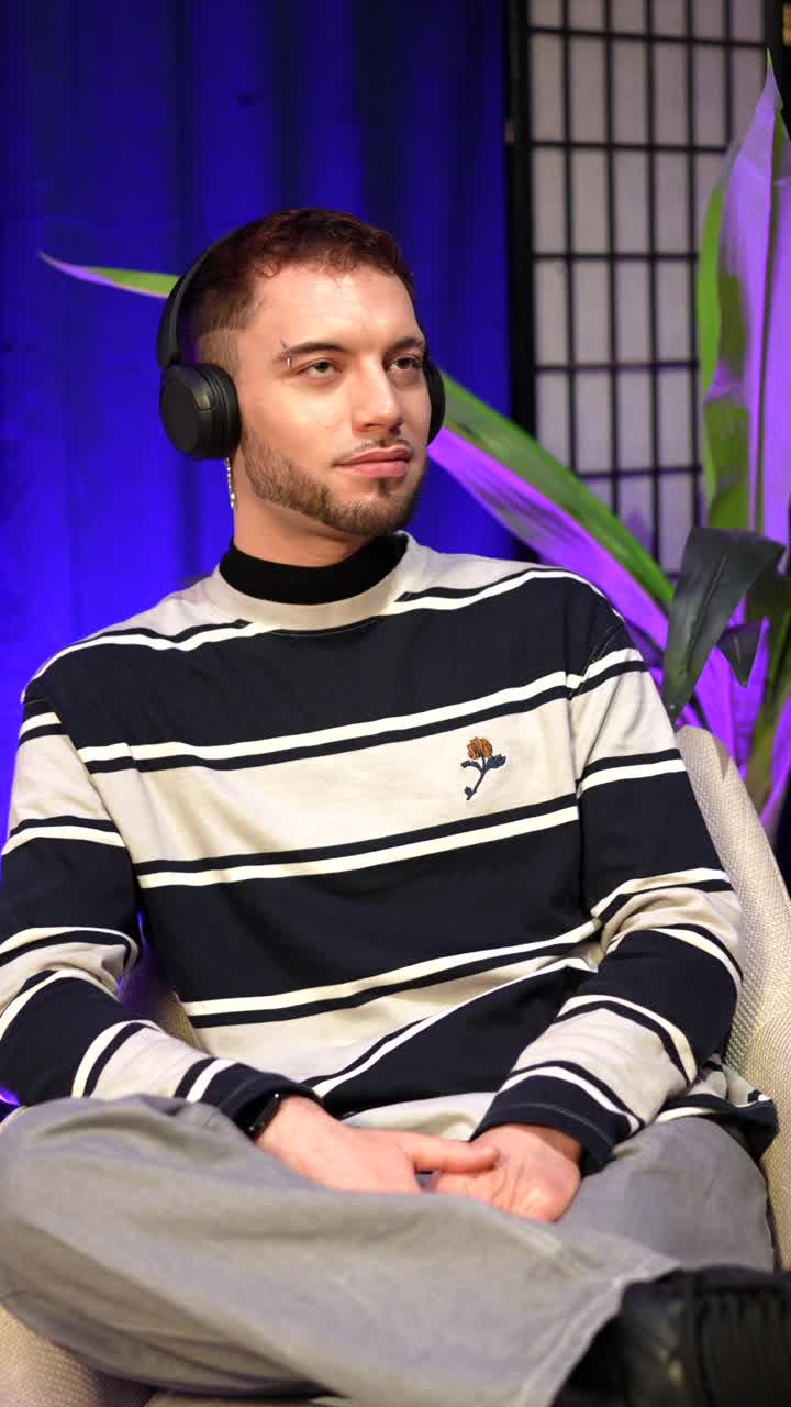 Jovem com fones de ouvido ouvindo e conversando em um estúdio
