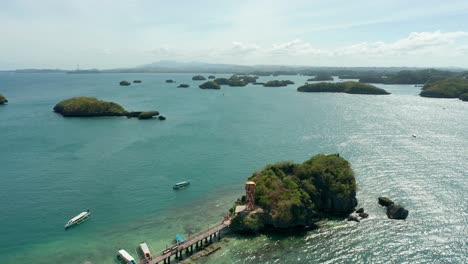 aerial view of tropical water landscape and banca boats docking at hundred islands resort, philippines in 4k