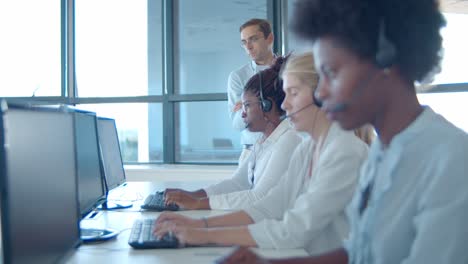 male call center boss and operators in headsets