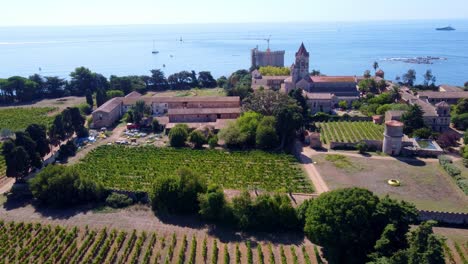 Flying-around-the-monastry-and-vineyard,-with-mediterranean-sea-in-the-background,-in-Saint-Honorat-island-part-of-the-Iles-de-Lérins,-next-to-Cannes-in-south-of-France