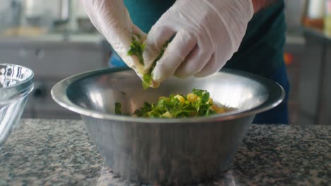 el cocinero está mezclando las verduras en un bol