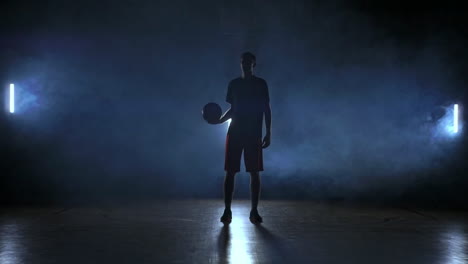 basketball player throws and catches the ball in the smoke