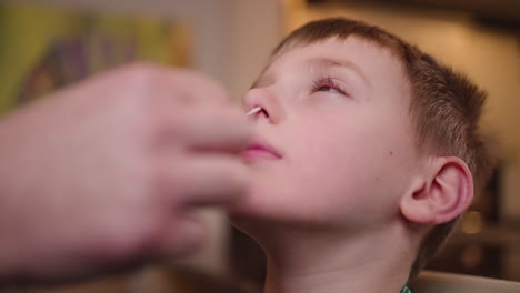 a young boy gets an at-home rapid antigen covid-19 test