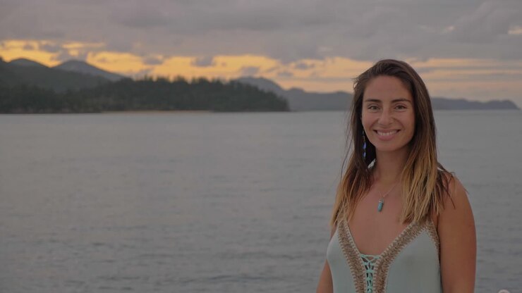 hermosa mujer feliz sonriendo con hook island pasaje en segundo plano.