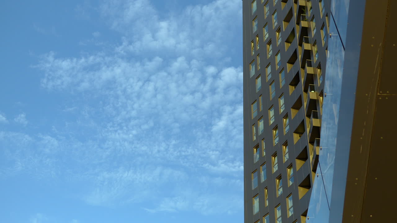 edificio de gran altura con ventanas de tonos dorados contra un cielo azul