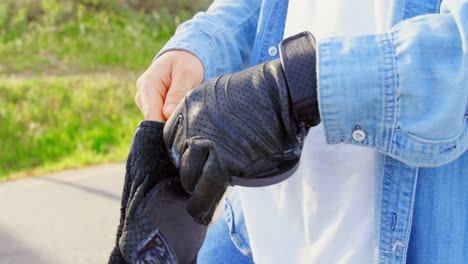 Close-up-of-young-male-skateboarder-wearing-skateboard-gloves-in-the-sunshine-4k