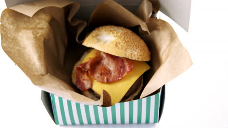 hamburger in a take away container on table