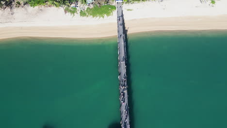 Aerial-view-of-Ferry-port-between-Koh-Samui-and-Koh-Tao,-travel-holiday-destination-in-Thailand-tropical-beaches-in-south-east-asia-aerial-top-down-of-wooden-bridge-connection-and-fast-ferry-boat