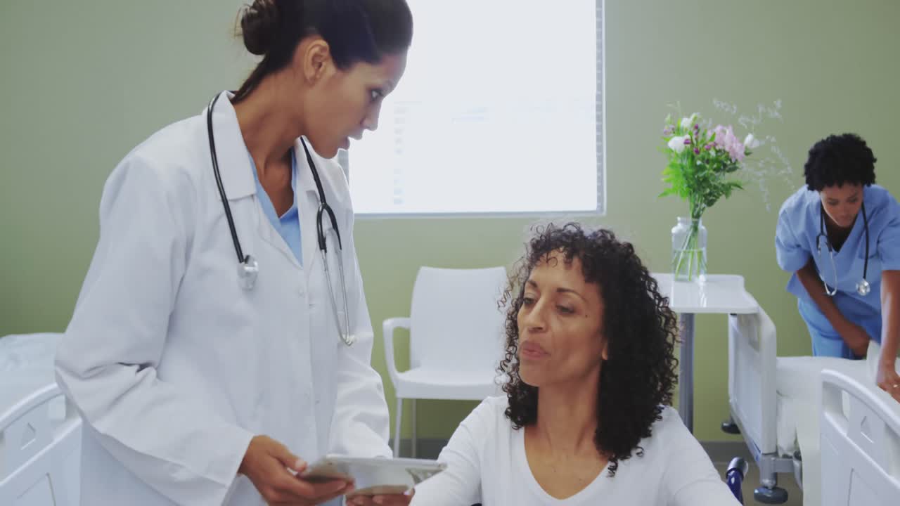 Front view of African american female doctor discussing medical report with disabled female patient