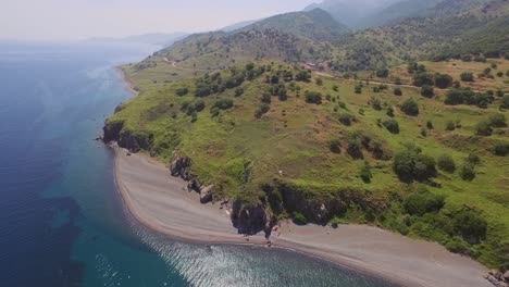 Aerial:-A-quiet-beach-with-a-fishing-boat-on-Lesbos,-near-Turkey