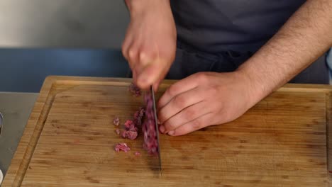 a man chops meat on a cutting board