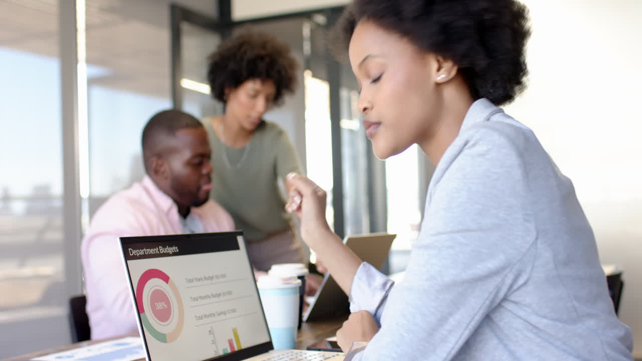 Diverse business colleagues brainstorming project ideas around a laptop