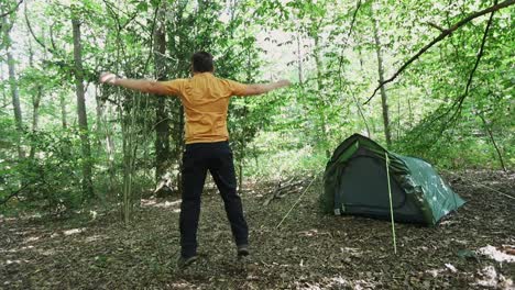 Joven-Haciendo-Saltos-En-El-Campamento-Del-Bosque,-Vista-En-Cámara-Lenta-Desde-Atrás