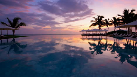 tropical sunset over an infinity pool at a luxury resort