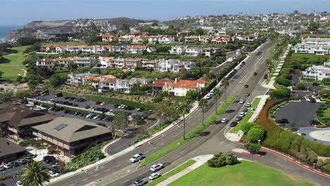 Drone-footage-of-houses-on-a-hill-with-cars-driving-by