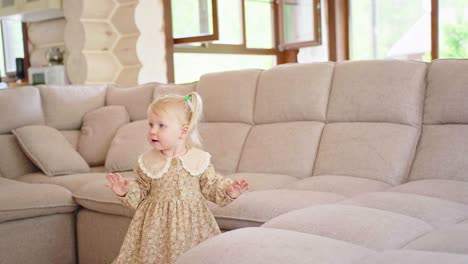 toddler exploring a beige sectional couch in a living room