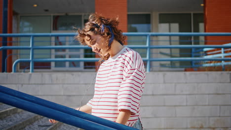 positive lady listening song in retro headset at sunny street. woman dancing