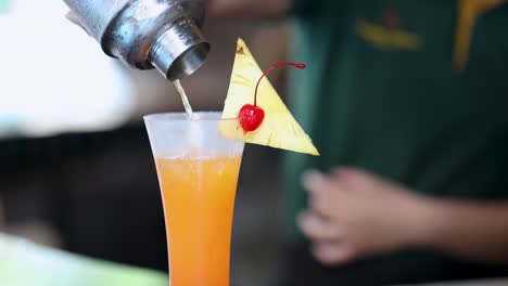 bartender prepares a vibrant fruit cocktail drink