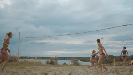 unofficial competition of beach volleyball between women female players are jumping and passing ball to each other