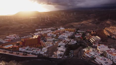 Stunning-aerial-view,-Town-with-houses-and-windmills-at-coast-beach-of-travel-destination-island-tenerife-during-golden-hour-evening-summer-sun