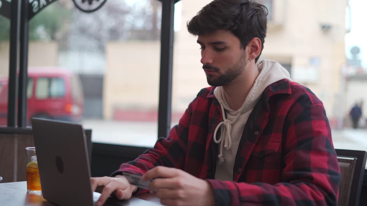 Cheerful man making online payment via laptop