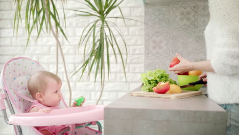 Cute-baby-watching-her-mother-cooking-food