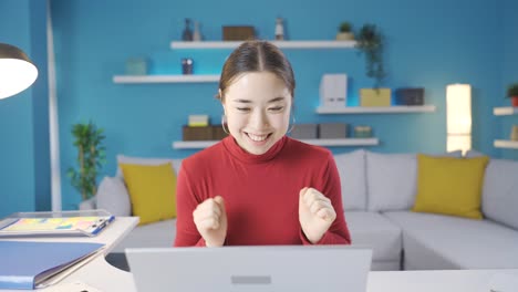 Asiatische-Frau,-Die-Im-Heimbüro-Arbeitet-Und-In-Fröhlicher-Und-Launischer-Stimmung-Am-Laptop-Arbeitet.