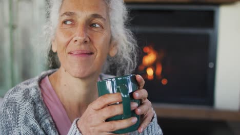 Senior-mixed-race-woman-holding-mug-and-smiling