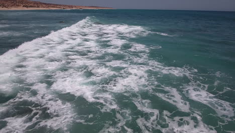 Low-fly-over-drone-footage-over-ocean-at-Cabo-San-Lucas,-Mexico-with-sweeping-waves