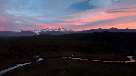 Beautiful-view-of-New-Zealand-natural-landscape,-high-mountain-range-on-horizon-during-colorful-dawn---aerial-panoramic