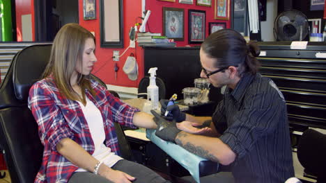 Woman-Sits-In-Chair-Having-Tattoo-In-Parlor-Shot-On-R3D