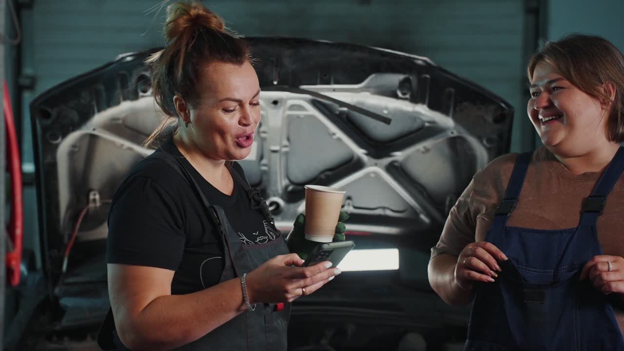 Women Mechanics Having Coffee Break in Garage