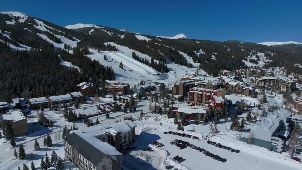 drone aéreo cobre montaña invierno esquí snowboard resort medio tubo entrenamiento práctica trucos competencia colorado fresco frío temprano en la mañana nieve fresca alojamiento aparcamiento cinematográfico dolly movimiento hacia arriba 4k