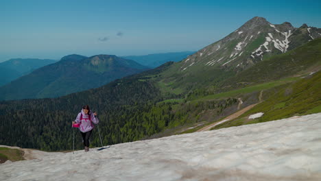 mujer caminando en montañas nevadas