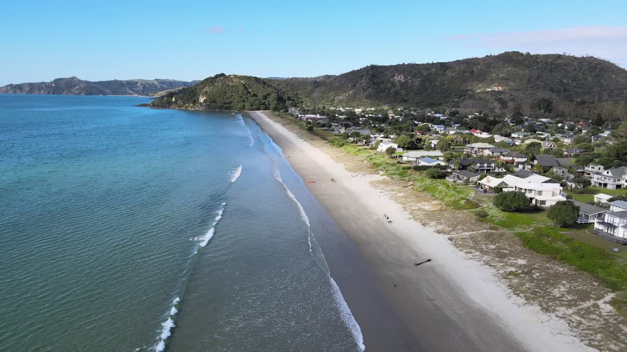 casas de vacaciones en una playa de arena, lugar popular para relajarse, península de coromandel, nueva zelanda