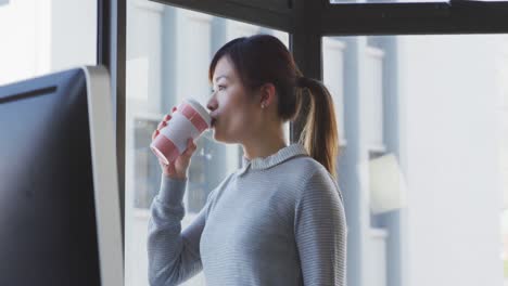 Businesswoman-drinking-coffee-in-modern-office