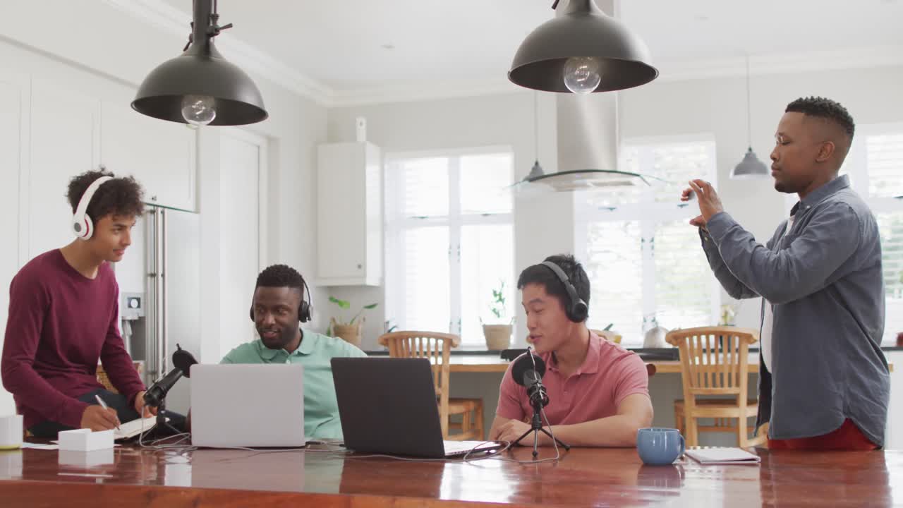 Happy diverse male friends talking and recording in living room