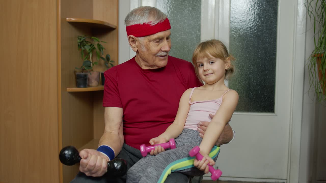 Nonno anziano attivo con bambina che fa esercizi di fitness con manubri