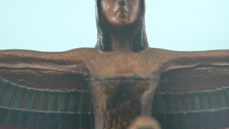 dreamy macro shot of a cleopatra statue with wide open wings, hazy depth of field, ancient egypt queen of kings, egyptian dynasty historical ruler, antique artwork of a goddess, 4k video tilt up