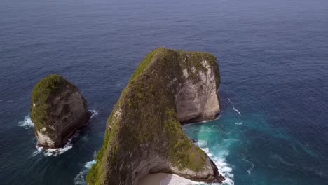 Fantástica-Vista-Aérea-Vuelo-Deslizador-Volar-Lateralmente-De-Izquierda-A-Derecha-Tiro-De-Dron-Playa-Kelingking-En-Nusa-Penida-Bali-Indonesia-Es-Como-Parque-Jurásico-Naturaleza-Cinematográfica-Vista-Del-Acantilado-Arriba-Por-Philipp-Marnitz