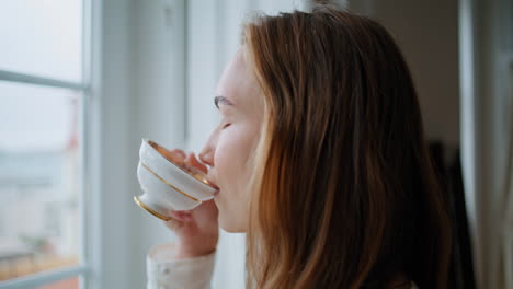 Frauenhände-Halten-Eine-Tasse-Tee-Am-Fenster,-Nahaufnahme.-Zufriedene-Dame-Schnuppert-Kaffee