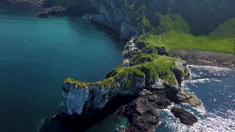 Kinbane-Castle-in-County-Antrim,-Northern-Ireland,-on-a-long,-narrow-limestone-headland-projecting-into-the-sea,-aerial-shot