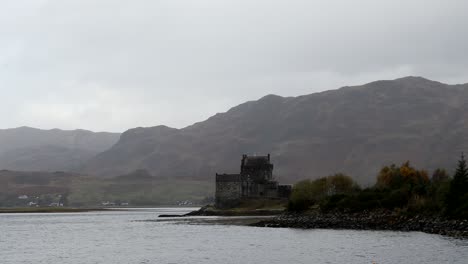 Castillo-De-Eilean-Donan,-Tierras-Altas,-Escocia,-Con-Cielos-Oscuros-Y-Nubes-Y-Montañas