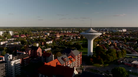 Örebro-water-tower,-Svampen,-drone-aerial-over-the-cityscape,-skyline,-evening