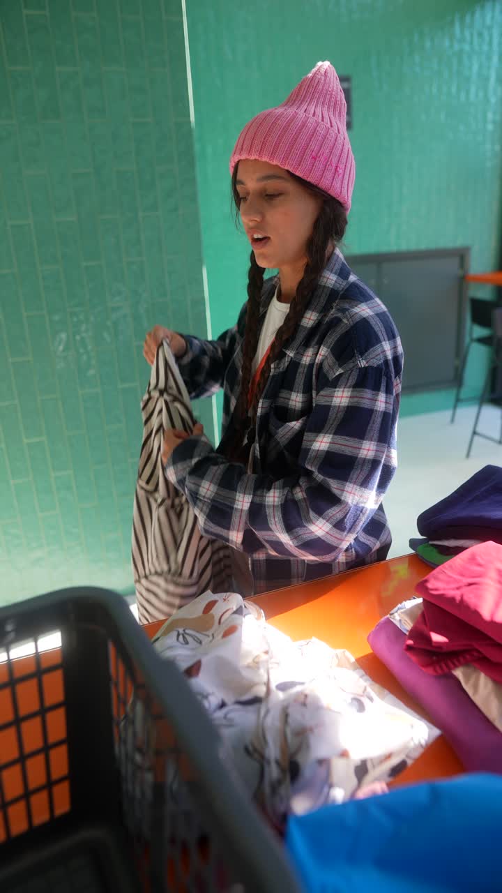 mujer clasificando la ropa en una lavandería automática