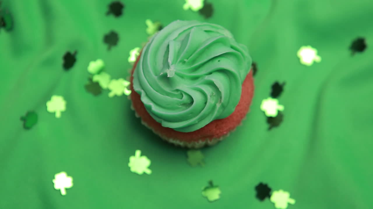 Cupcake di San Patrizio che ruota con coriandoli a forma di trifoglio che cadono