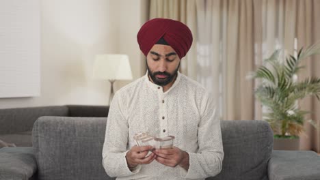 sad indian man counting money