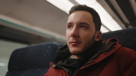 Young-man-on-European-train,-contemplative-look,-sitting-by-the-window