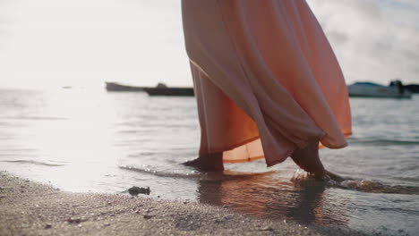 Close-up-of-a-woman's-feet-as-she-walks-barefoot-along-the-sandy-beach