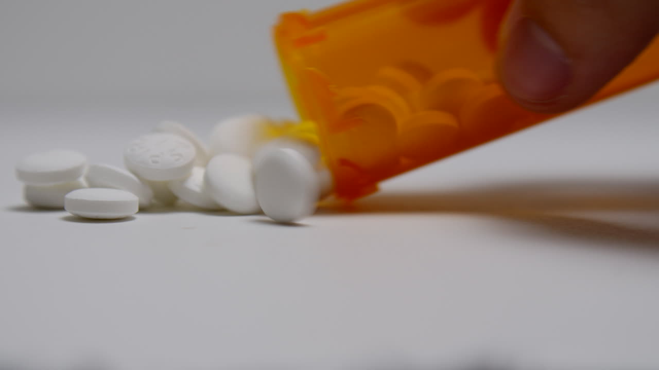 알약은 병에서 흰색 표면에 부어집니다.